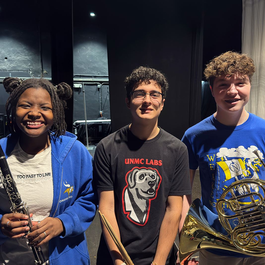 Three North High students with their instruments - a clarinet, drumsticks and french horn